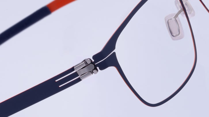 Close-up of navy ic! berlin eyeglasses with red accents