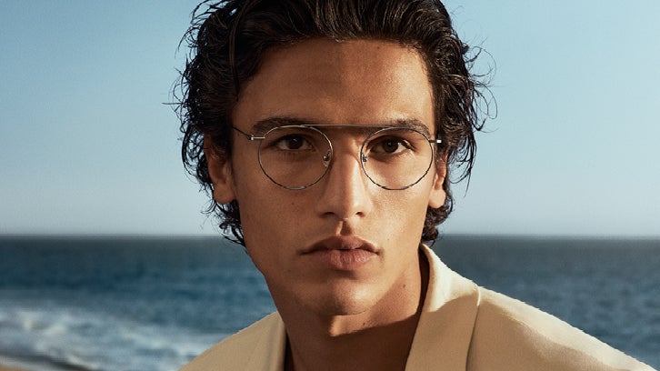 Male model wearing round silver Calvin Klein eyeglasses